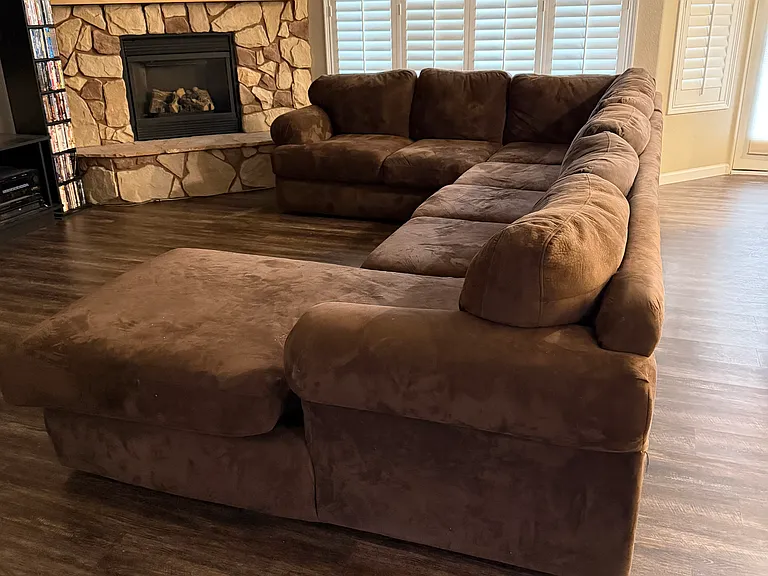 Open concept living space, stone wall, gas fireplace, white polymer shutters