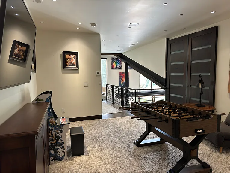 Upper landing. Has fooseball, sitting chairs. Large doors are to owner storage, no access for renters