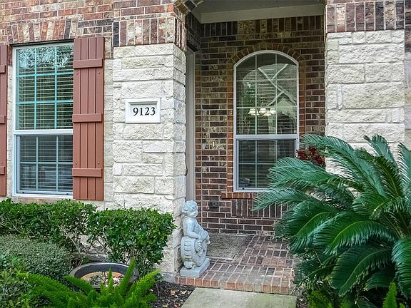 Lush landscaping and covered front porch greet your guests.