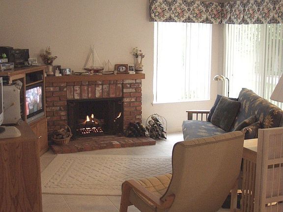Large Family Room with lots of afternoon sun light and cozy brick fireplace.