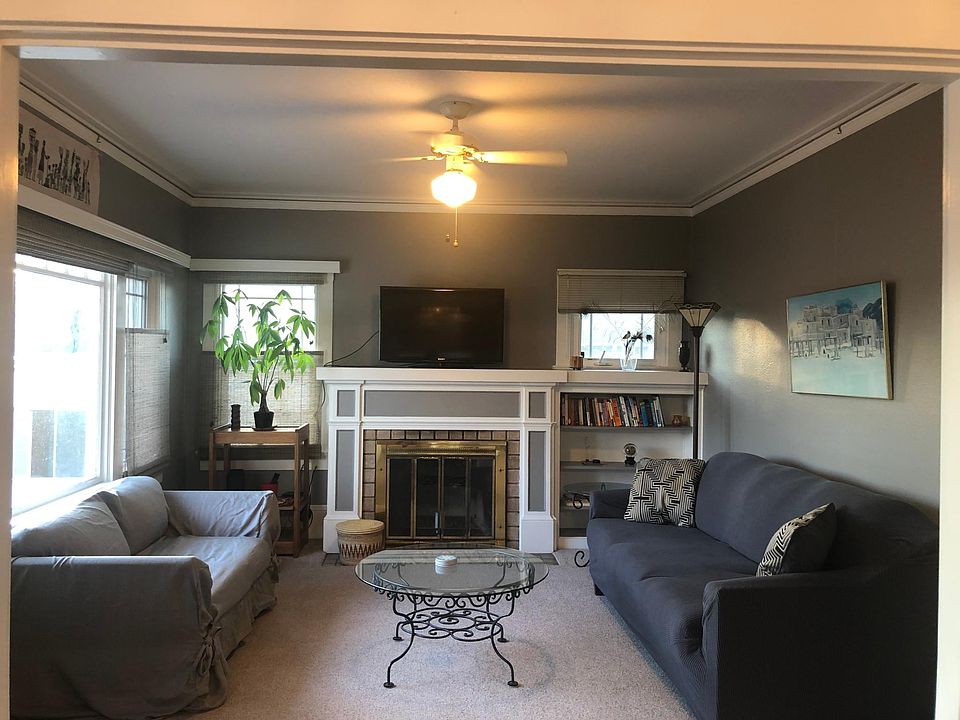 Spacious well lit livingroom with built in shelving, ceiling fan, fireplace and room for 2 couches