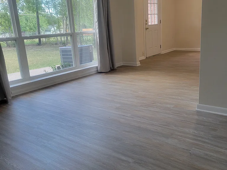 Living room with Picture window, and adjacent room off living room with door to backyard.