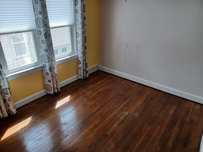 Bedroom 2 view 2 with newer windows and optional window treatments for tenant use.