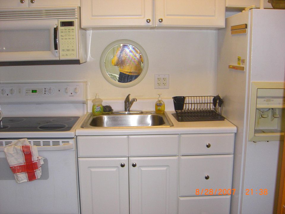 Large white kitchen with full size refrigerator, stove/oven, built in microwave