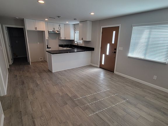 Across living room to kitchen, breakfast/work at home/homework bar and locations for stove and refrigerator