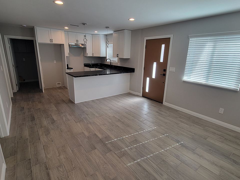 Across living room to kitchen, breakfast/work at home/homework bar and locations for stove and refrigerator