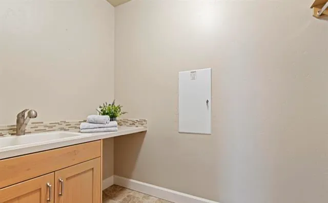 LAUNDRY ROOM. THERE IS A LARGE WASH BASIN AND BELOW STORAGE.
