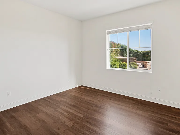 Spare Bedroom 1 Downstairs with backyard view and hardwood flooring