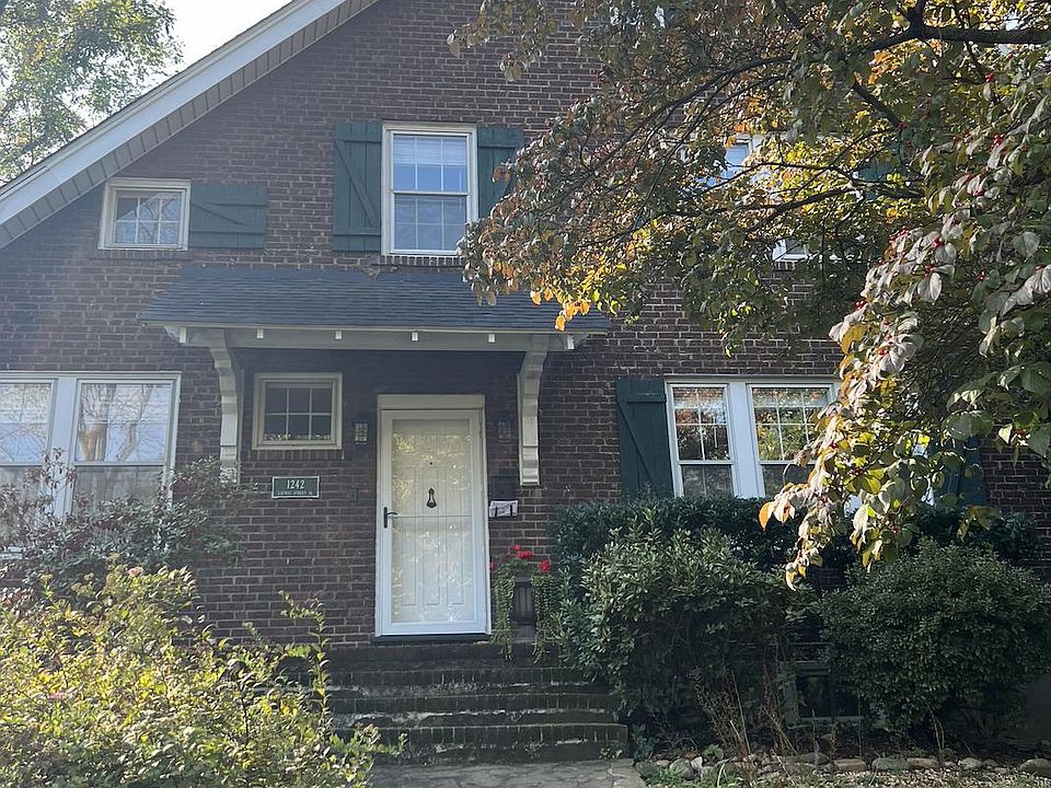 Front of house with mature trees and morning sun