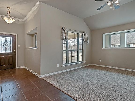 Custom front door with the Lone Star etched in glazed glass opens to ceramic tile entryway and large dining room.