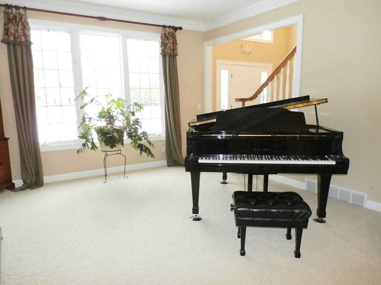 The formal living room features windows with a southern exposure, crown molding, and custom drapery.