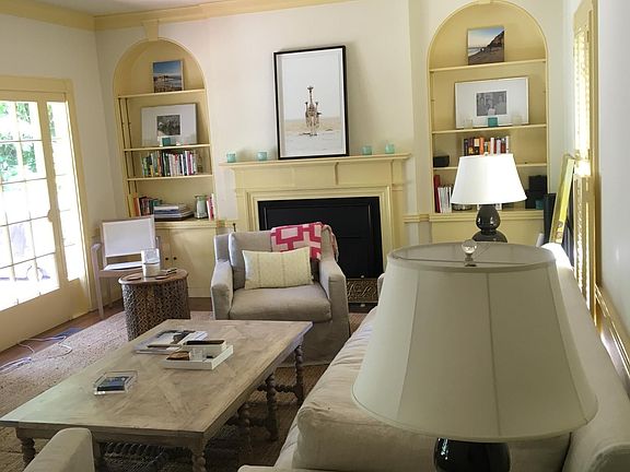 Beautiful large living room with classic built in shelving and mantle and gas fireplace. Opens to the back yard.