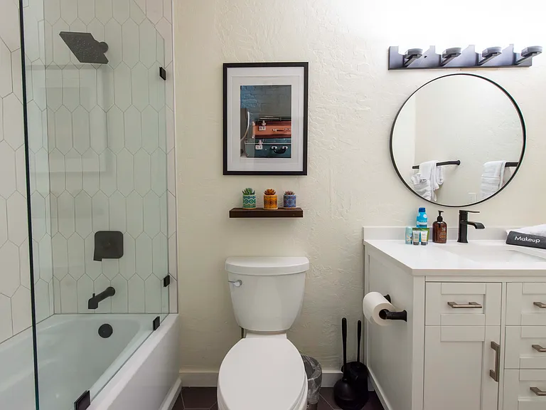 Bathroom of second master with single vanity and tub/shower combo