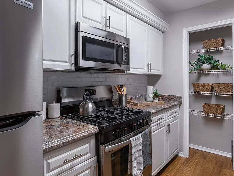 Fully equipped kitchen with stainless steel appliances, subway tile backsplash, and a convenient pantryperfect for any home chef.