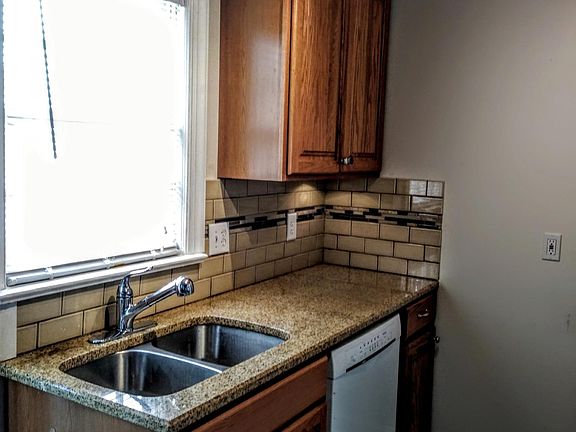 Kitchen East wall with granite counter tops, deep double sinks and dish washer.