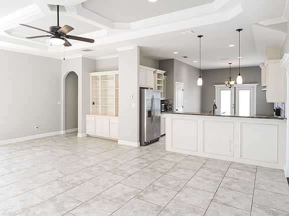 living room with built-in cabinets that's open to kitchen