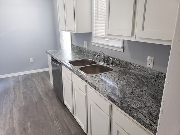 Bright white cabinets being installed with new countertop and flooring