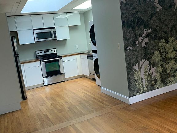 U shaped kitchen with large skylight and plenty of cabinet space for storage and new washer and dryer.