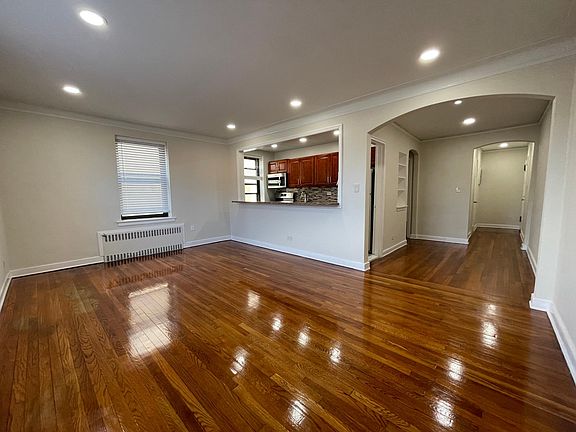 Large living room with in-ceiling LED lighting and refinished floors