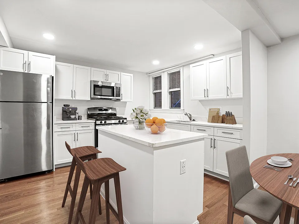 Modern kitchen with sleek stainless steel appliances, elegant white cabinetry, and a cozy breakfast nook with stylish seating.