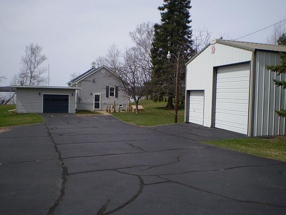 View of main house, 2 car garage, and outbuilding from driveway