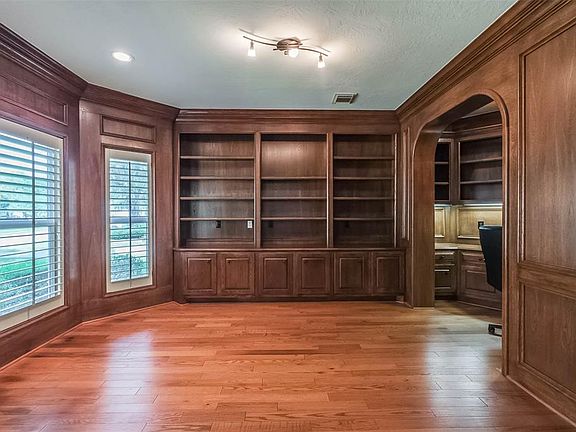 Handsome wood paneled study with built ins overlooks the front of the home and is located to the left of the foyer.