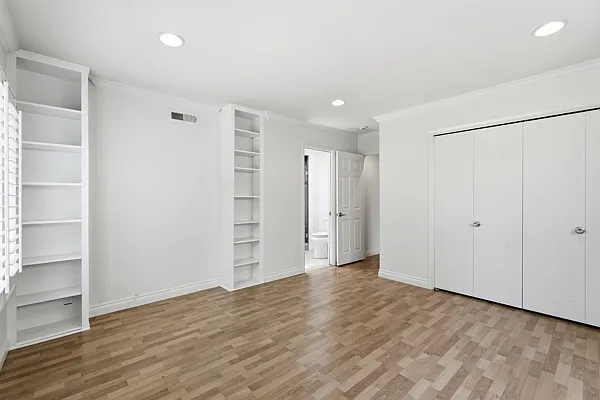 Primary bedroom with built-in bookcases, storage.