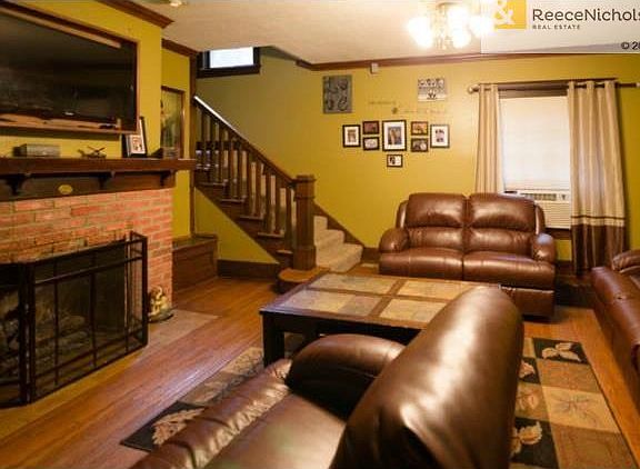 Living room has original hardwood floors, wood trim, Mantle and