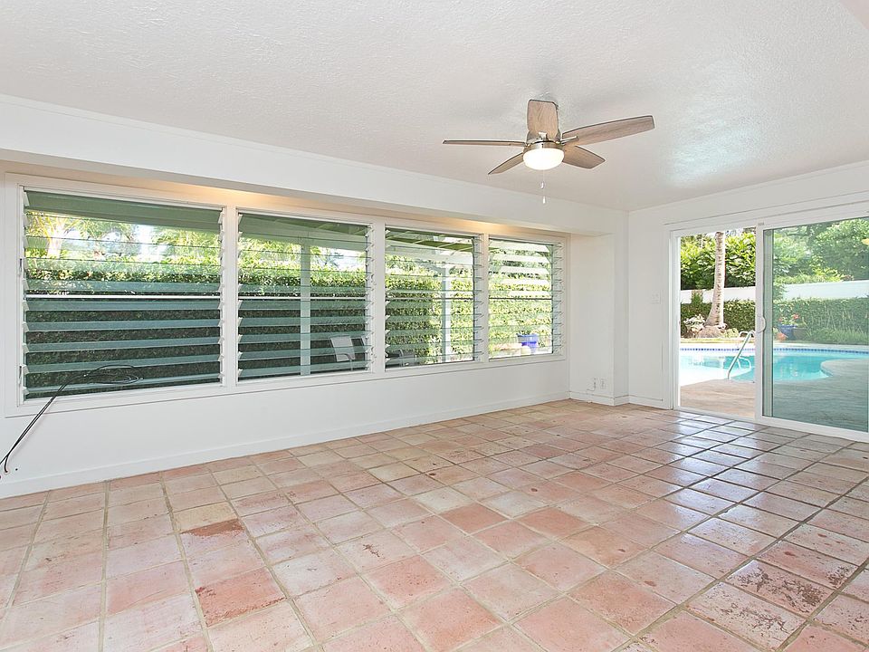 Family room, outside pool and lanai. All rose tile floors will be replaced with new flooring.