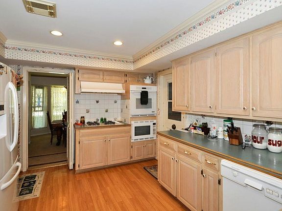 Kitchen has beautiful cabinets and hardwood floors