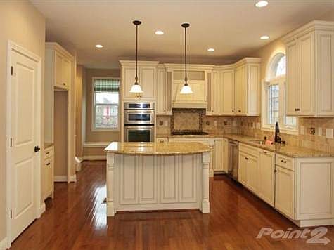 The chef's kitchen offers granite countertops, & an abundance of glazed cabintry & tiled backsplash.