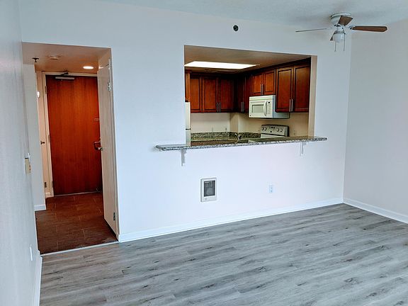 Living room looking at kitchen and entry.