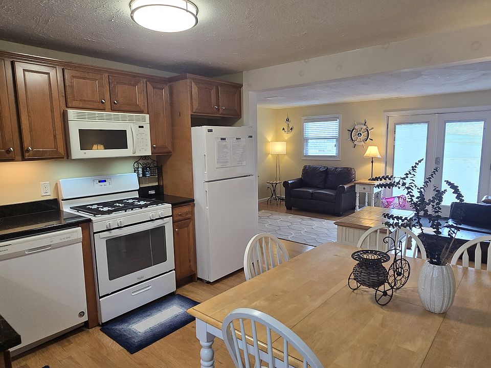 Fully applianced kitchen, with gas stove/oven, microwave, refrigerator, dishwasher, coffee pot, tea pot, toaster oven.