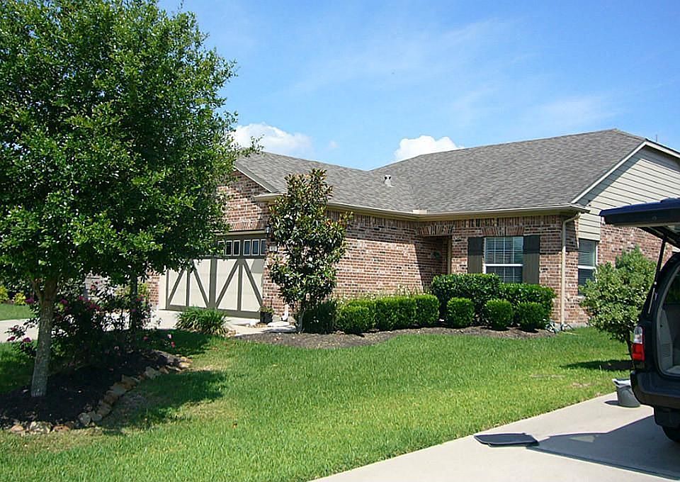 Beautiful landscaped front yard features large Oaks trees and a flowering Magnolia.