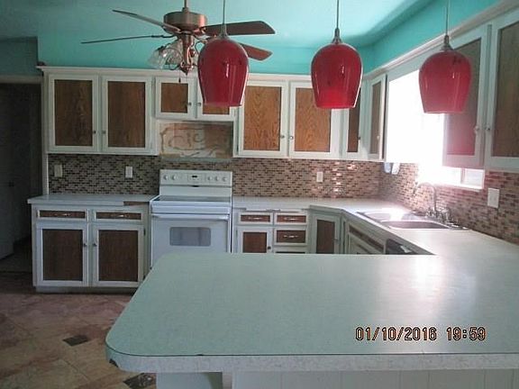 U-shaped kitchen with smooth top slide in range, stainless steel dishwasher, breakfast bar, ceramic tile floors, glass backspash  and large pantry.  Microwave has been removed.