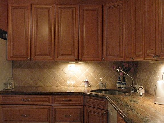 New cherry kitchen with granite countertops and backsplash