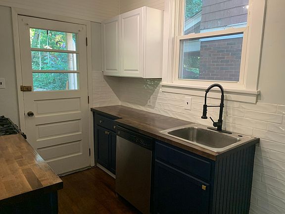 Kitchen features dishwasher, garbage disposal, gas range, hardwood floor, and butcher block counters.