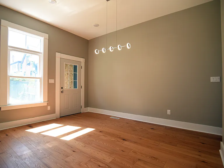 Dining room area with chandelier above . Door leading into yard.
