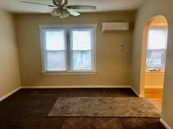 Living/Bedroom area looking to exterior front, mini-split HVAC on front wall. Entry area to right in photo.