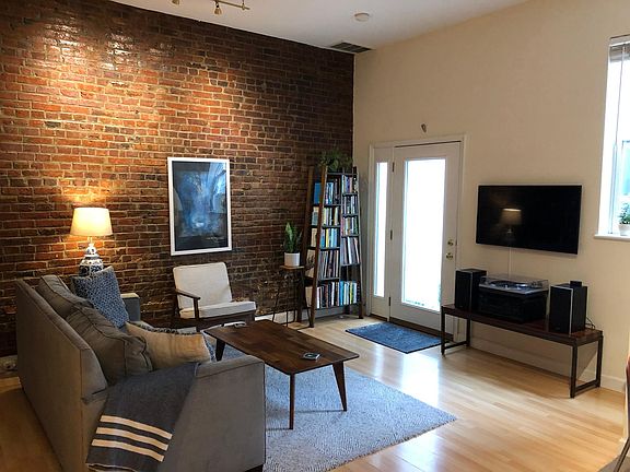 Living area with exposed brick and high ceilings
