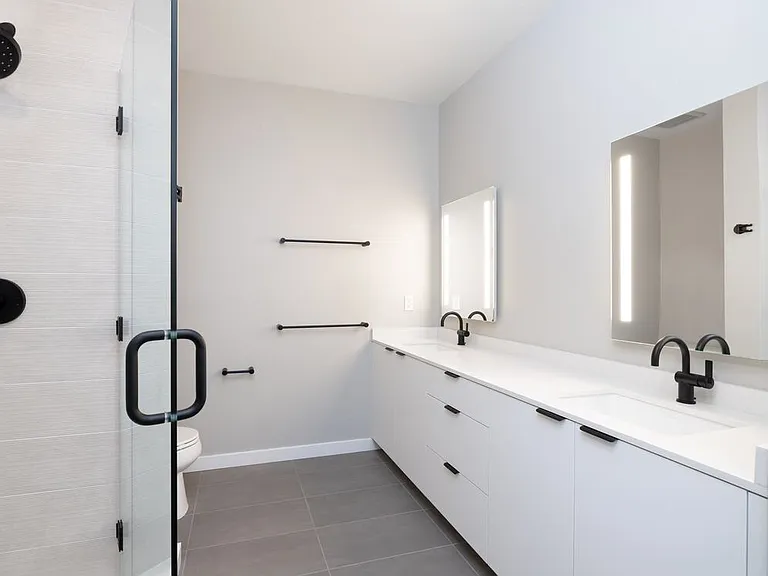 Signature Collection II Primary bath with dual vanity sinks, white cabinetry, LED lit mirror, white quartz countertops, and tile flooring