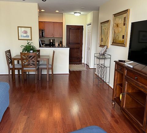 Looking from balcony toward front door entrance. Bright, open floor plan.