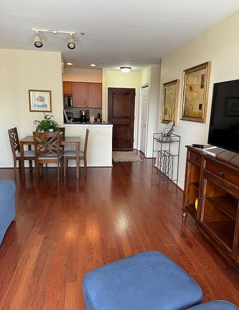 Looking from balcony toward front door entrance. Bright, open floor plan.