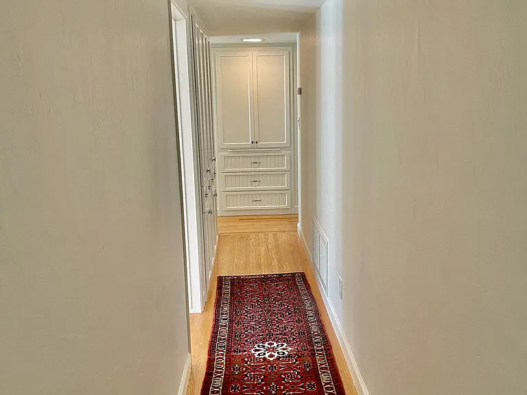 Hallway with generous built-in storage cabinets and drawers