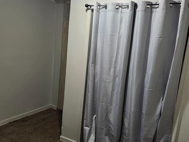 Private sleeping area with wall-to-wall carpet and a ceiling light, plus a curtain partition for added privacy.