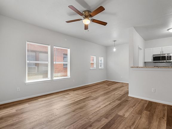 This spacious living room features sleek luxury vinyl plank flooring and a ceiling fan.