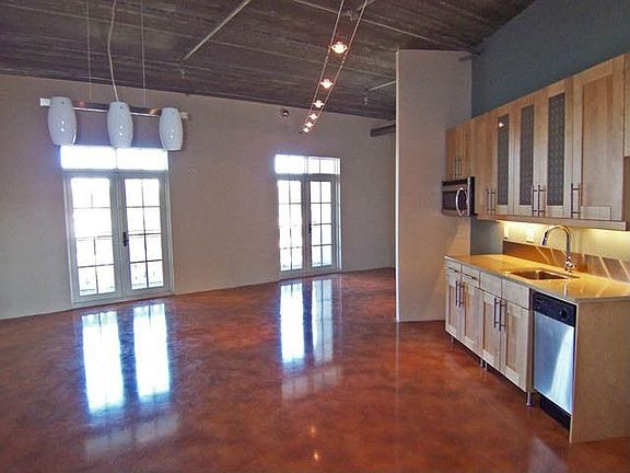 Grand living space w/ soaring ceiling, track lighting, gleaming concrete floor