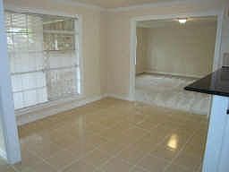 Spacious dining room with tile floors and crown molding.