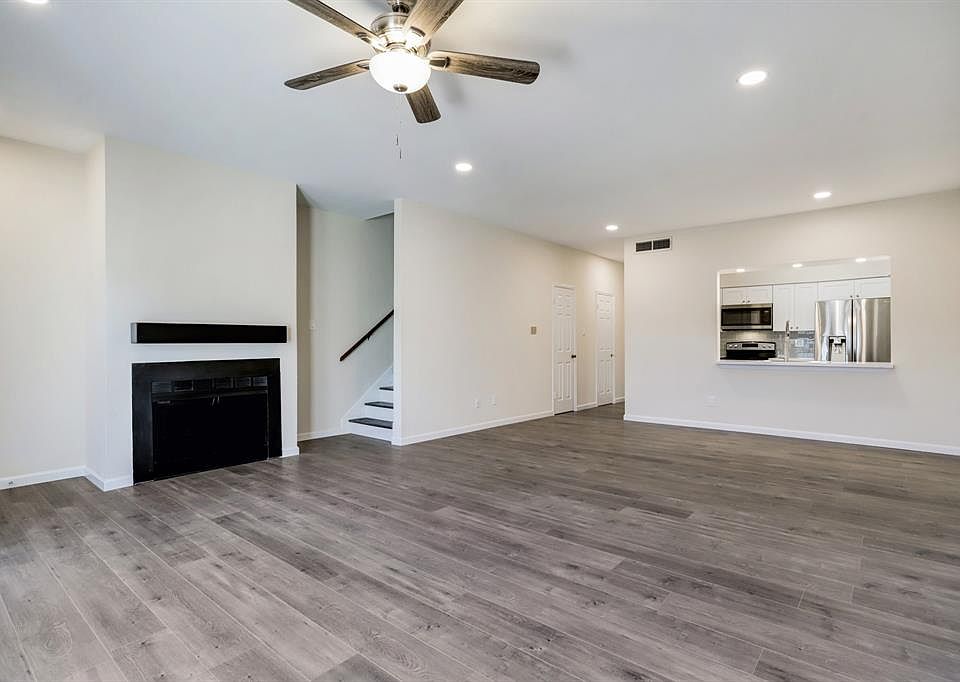 This second view of the living room takes you into the kitchen and features the fireplace and stairs leading you to the bedrooms.