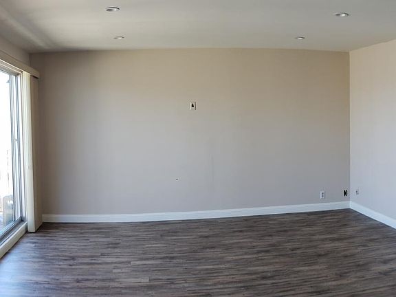 Living room with floor to ceiling sliding door to a small balcony overlooking the Bay, North Beach, Telegraph Hill, and Coit tower.